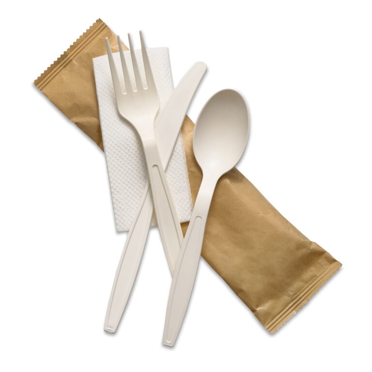 Cornstarch cutlery kit with a white fork, knife and spoon, napkin, and brown sealed pouch.