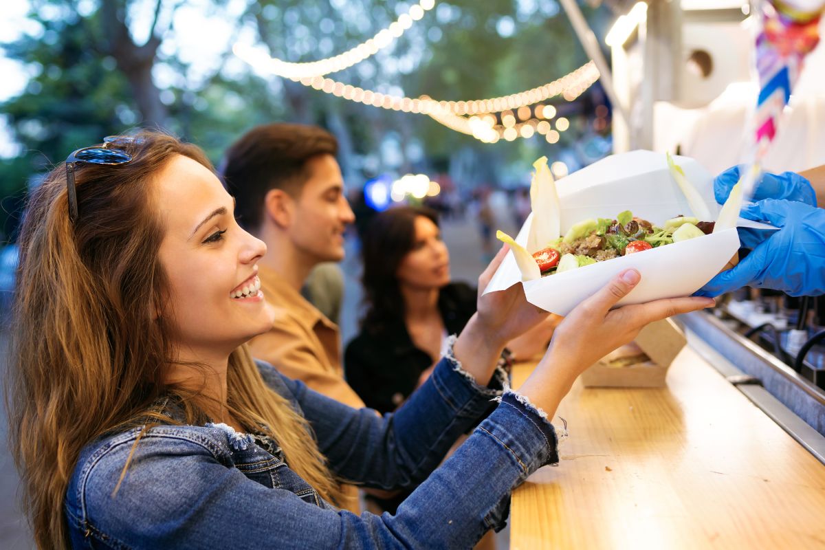 Street vendor serving food in recyclable packaging
