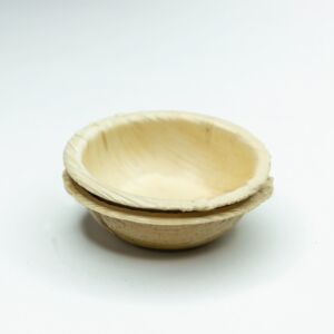 Empty 3-inch round palm leaf dip bowls on a plain background